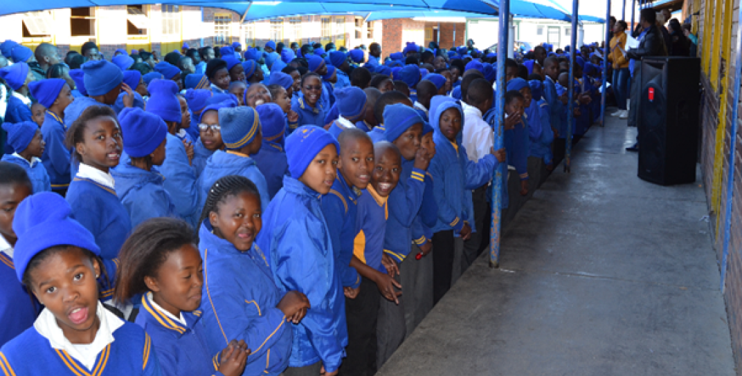 Group of students in blue uniforms standing in a line